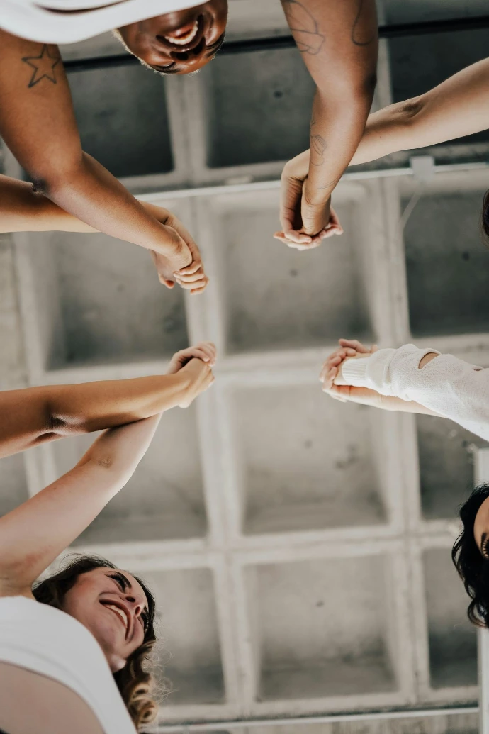 a group of people standing in a circle holding hands