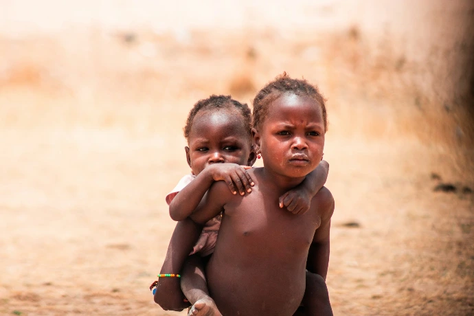 A couple of kids standing next to each other